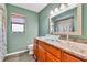 Unique bathroom features a glass vessel sink, wood cabinets, and a window at 910 Kingscote Ct, Safety Harbor, FL 34695