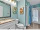 Charming bathroom offers coastal decor, and a shower with an open doorway to the pool area at 910 Kingscote Ct, Safety Harbor, FL 34695
