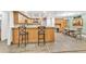 Open-concept kitchen features wood cabinets, granite countertops, and a breakfast bar that connects to the dining area at 910 Kingscote Ct, Safety Harbor, FL 34695