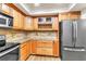 Bright kitchen with wood cabinets, tile backsplash, and stainless steel appliances offers modern functionality and style at 910 Kingscote Ct, Safety Harbor, FL 34695