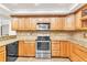 Well-equipped kitchen with stainless steel appliances, wood cabinets, and ample countertop space for cooking and entertaining at 910 Kingscote Ct, Safety Harbor, FL 34695