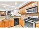 Modern kitchen features stainless steel appliances, wood cabinets, and a convenient layout for cooking and meal preparation at 910 Kingscote Ct, Safety Harbor, FL 34695