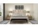Inviting main bedroom featuring a upholstered headboard, bench, and symmetrical nightstands at 9509 Minnow Ray Dr, Land O Lakes, FL 34638