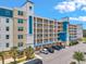 An exterior view of a multi-story condo featuring balconies, well-manicured landscaping, and convenient parking spaces at 960 Starkey Rd # 10505, Largo, FL 33771