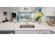 Bright kitchen with white countertops, stainless sink, and a view into the living area at 960 Starkey Rd # 10505, Largo, FL 33771