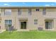 View of the rear of the home showcasing a well-maintained lawn, patio area, and convenient sliding glass door access at 9907 Carlsdale Dr, Riverview, FL 33578