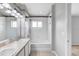 Well-lit bathroom with double sinks, modern vanity, bathtub, and shower with tiled surround at 9907 Carlsdale Dr, Riverview, FL 33578