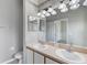 Bathroom with double sink vanity, stylish lighting, and well-lit mirror at 9907 Carlsdale Dr, Riverview, FL 33578
