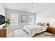 Bright main bedroom featuring a bed, nightstands, lamps and windows at 9907 Carlsdale Dr, Riverview, FL 33578