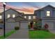 Charming townhome exterior featuring a well-maintained lawn and attached garage at 9907 Carlsdale Dr, Riverview, FL 33578