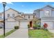 Charming townhome exterior featuring a well-maintained lawn and attached garage at 9907 Carlsdale Dr, Riverview, FL 33578