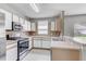 Functional kitchen featuring stainless steel appliances, bright lighting, and a breakfast bar at 9907 Carlsdale Dr, Riverview, FL 33578