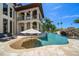 Luxury backyard featuring a pool with water slide, splash pad, sun loungers, and a manicured lawn at 10930 Spring St, Largo, FL 33774