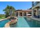 This backyard features a custom pool with rock features, grotto, water slide, outdoor kitchen and spa at 10930 Spring St, Largo, FL 33774