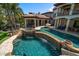 Beautiful backyard oasis featuring a custom pool with rock features, slide, grotto, outdoor kitchen and spa at 10930 Spring St, Largo, FL 33774
