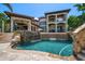 Expansive backyard featuring a custom pool with rock features, a slide, a grotto, and a full outdoor kitchen at 10930 Spring St, Largo, FL 33774