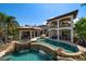 Expansive backyard featuring a custom pool with rock features, a slide, a grotto, and a full outdoor kitchen at 10930 Spring St, Largo, FL 33774