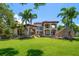 Beautiful backyard with a vast lawn, stone accents, and an elegant home exterior perfect for outdoor living at 10930 Spring St, Largo, FL 33774