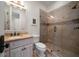 Modern bathroom with a glass shower, toilet, and vanity with a granite countertop, and updated fixtures at 10930 Spring St, Largo, FL 33774