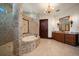 Opulent bathroom featuring mosaic tile walls, a curved bathtub, a walk-in shower, and a wooden door at 10930 Spring St, Largo, FL 33774