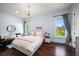 Bright bedroom with light blue walls, hardwood floors, and large windows, offering a serene and airy atmosphere at 10930 Spring St, Largo, FL 33774