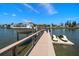 Private boat dock featuring a boat lift and jet ski platform along a canal with nearby waterfront homes at 10930 Spring St, Largo, FL 33774