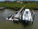 Aerial view of a private boat dock featuring multiple boat slips and a well-maintained dock structure at 10930 Spring St, Largo, FL 33774