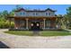 Inviting barn-style home with a covered porch, stone accents, and ample outdoor space, blending rustic charm at 10930 Spring St, Largo, FL 33774