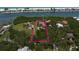 Aerial view highlighting the estate's positioning with pristine waterfront, mature trees, and well-maintained lawns at 10930 Spring St, Largo, FL 33774