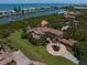 Aerial view showcasing a luxurious waterfront home with a circular driveway and mature landscaping at 10930 Spring St, Largo, FL 33774