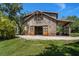 Picturesque barn-style home featuring sliding barn doors and a cozy covered porch with a peaceful outdoor setting at 10930 Spring St, Largo, FL 33774