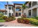 A Mediterranean-style home featuring lush landscaping leading to a grand entrance with a brick driveway at 10930 Spring St, Largo, FL 33774