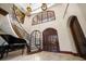 The grand foyer has a curved staircase, a piano, double front doors, and soaring ceilings at 10930 Spring St, Largo, FL 33774