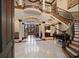 Grand foyer with soaring ceilings, travertine floors, and a sweeping staircase with custom iron railings at 10930 Spring St, Largo, FL 33774