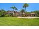 A Mediterranean-style home with manicured landscaping, a circular driveway, and a porte-cochere at 10930 Spring St, Largo, FL 33774