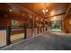 Well-lit horse barn boasting brick flooring, wooden walls, and individual stalls for horses at 10930 Spring St, Largo, FL 33774