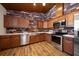 Rustic kitchen featuring stone accent wall, wooden cabinetry and stainless steel appliances at 10930 Spring St, Largo, FL 33774