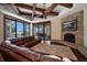 Inviting living room featuring a stone fireplace, wood beams, and seamless access to the outdoor pool area at 10930 Spring St, Largo, FL 33774