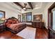 Comfortable primary bedroom with wood beams, a plush rug, hardwood floors, and natural light at 10930 Spring St, Largo, FL 33774
