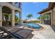 Relax in this backyard featuring a custom pool with beach entry, rock features, and a full outdoor kitchen at 10930 Spring St, Largo, FL 33774