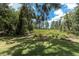 Scenic view of the backyard showcasing a wooden bridge surrounded by lush greenery and mature trees at 11008 Nest Ct, Odessa, FL 33556