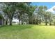 Expansive backyard featuring mature trees, a storage shed, and a lush lawn at 11008 Nest Ct, Odessa, FL 33556