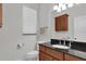 Bathroom featuring wood vanity with black countertop, modern sink and faucet, toilet, and window at 11008 Nest Ct, Odessa, FL 33556