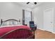 Comfortable bedroom with hardwood floors, featuring a bed, side table, and comfortable blue recliner at 11008 Nest Ct, Odessa, FL 33556