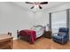 Simple bedroom with hardwood floors featuring a comfortable bed, side table, and a comfy chair at 11008 Nest Ct, Odessa, FL 33556