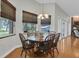 Cozy dining room with a round wooden table, six chairs, hardwood floors, and natural light at 11008 Nest Ct, Odessa, FL 33556
