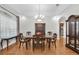 Dining room with hardwood floors, large window, and view into the kitchen at 11008 Nest Ct, Odessa, FL 33556