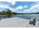Tranquil lake view from a modern dock with a bench, perfect for peaceful relaxation and enjoying the water at 11008 Nest Ct, Odessa, FL 33556
