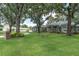 Beautiful home featuring a manicured lawn, mature trees, and a circular driveway at 11008 Nest Ct, Odessa, FL 33556