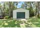 Detached garage with a roll-up door offers additional storage space or workshop potential at 11008 Nest Ct, Odessa, FL 33556